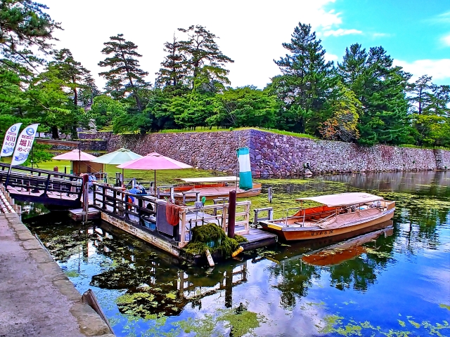Discover the charm of Tamatsukuri Onsen Izumo through a relaxing ride on the Horikawa Sightseeing Boat, gliding past historic bridges and seasonal landscapes surrounding Matsue Castle.