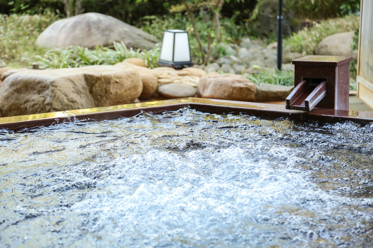 Outdoor hot spring bath with bubbling water at Arima Onsen