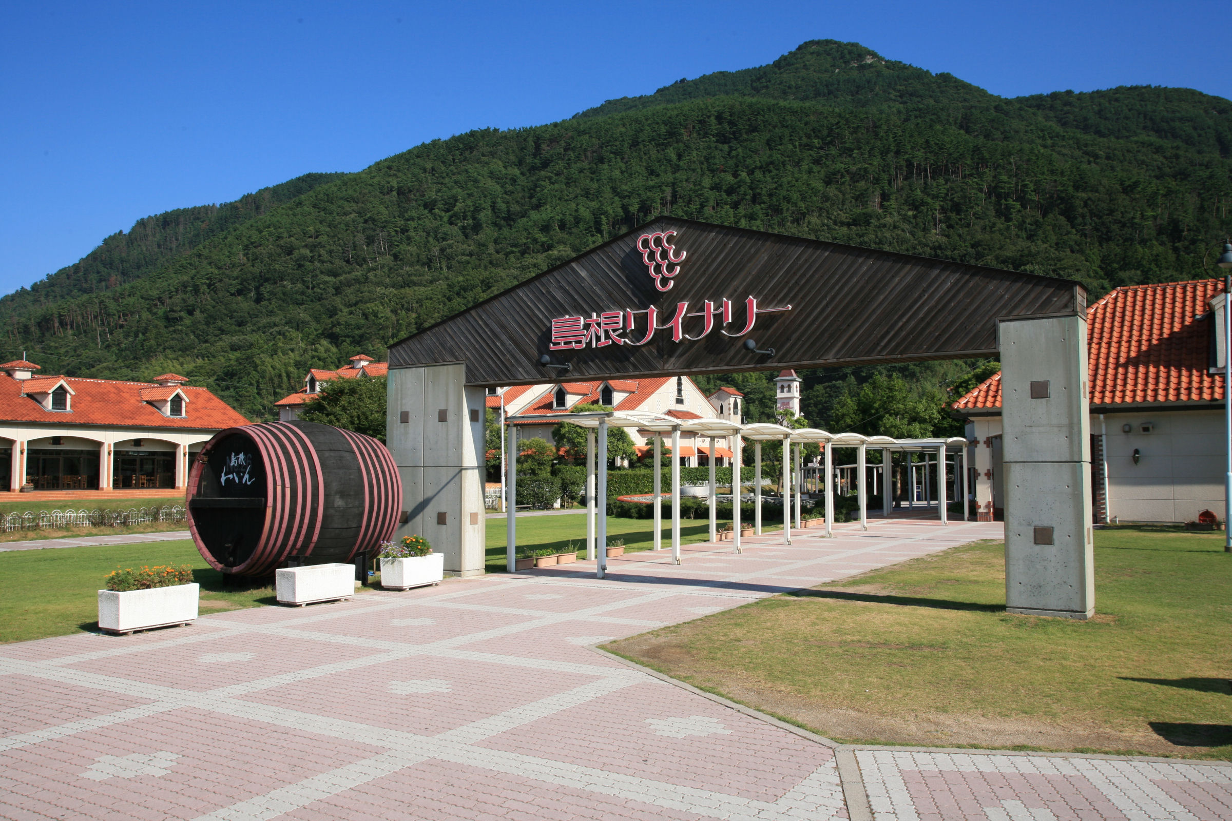 Tamatsukuri Onsen Izumo Shimane Winery surrounded by lush mountains and vibrant architecture.