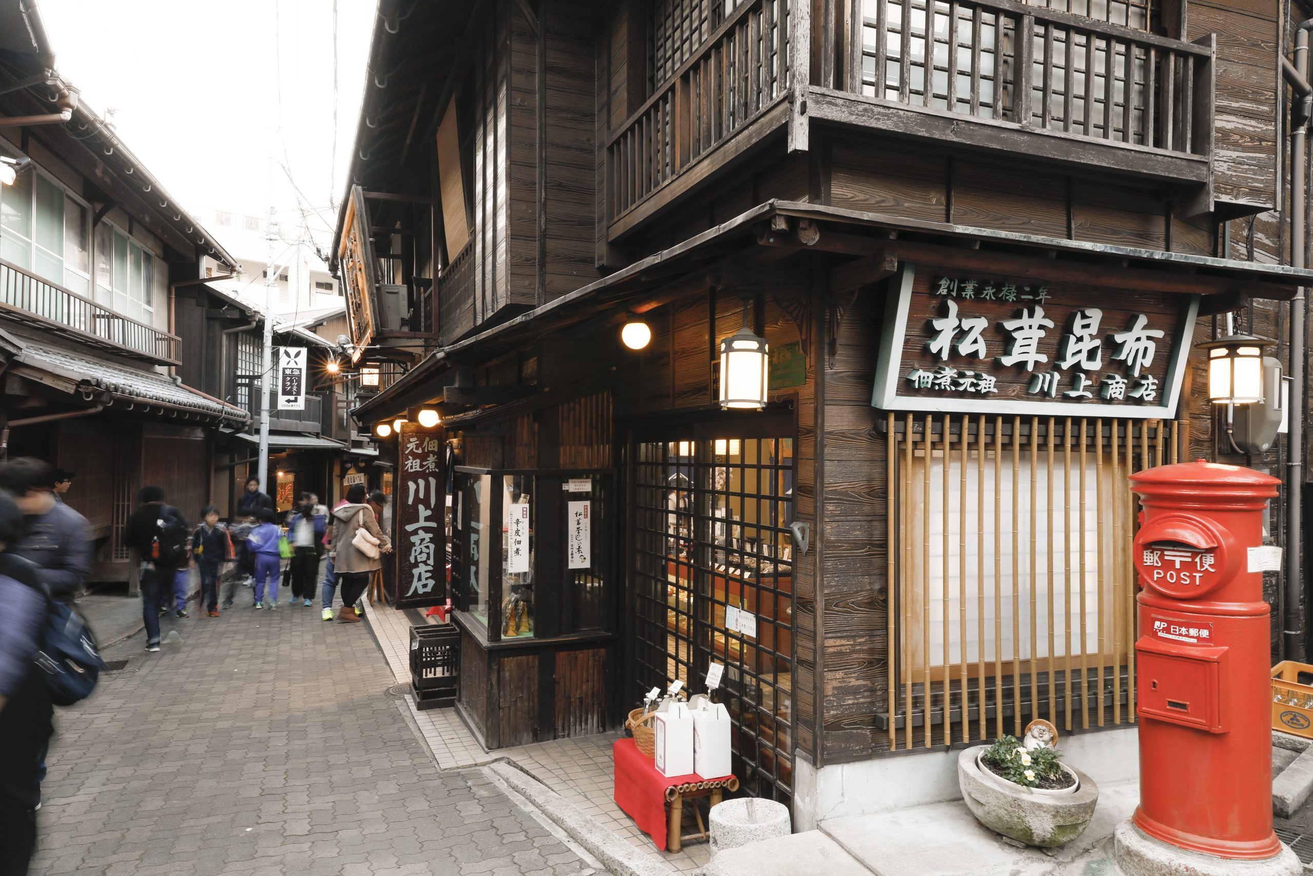 Traditional shopping street with old-style wooden buildings and red post box at Arima Onsen