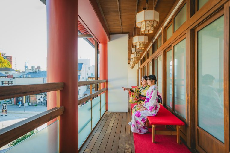 Two women in colorful yukata enjoying the view from the balcony of Dogo Onsen Annex Asuka-no-Yu.
